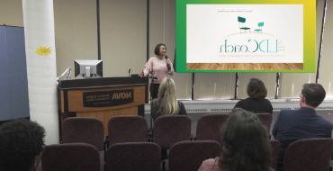 A person speaking at a podium in front of an audience